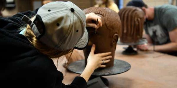 Students sculpting heads